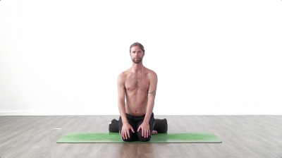 Yoga teacher performing simha mudra on green yoga mat on white background